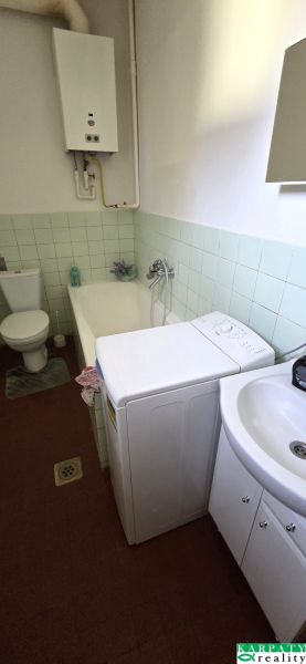 Badezimmer mit Badewanne, Waschbecken, Toilette und Waschmaschine in einem Einfamilienhaus.