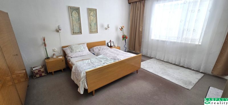Schlafzimmer in einem Einfamilienhaus mit Bett, Kleiderschrank und Dekorationen.