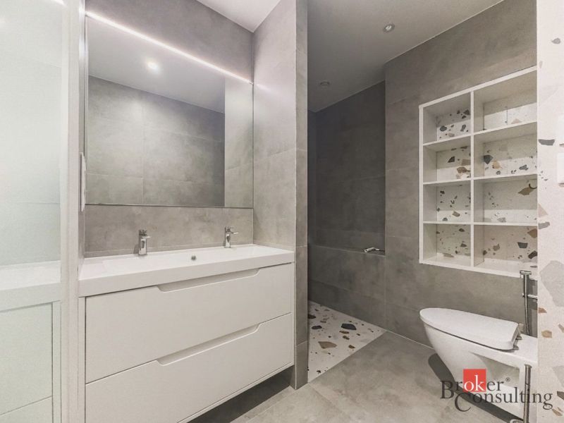 Badezimmer in einer 3-Zimmer-Wohnung mit Spiegel und Duschkabine, neutrale Farbtöne.
