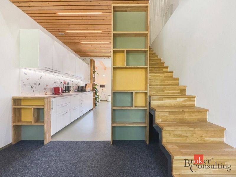 Küche mit weißen Schränken und Holzboden in einer 3-Zimmer-Wohnung.