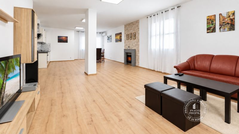 Wohnzimmer in einer 2-Zimmer-Wohnung mit Holzboden und einem bequemen roten Sofa.