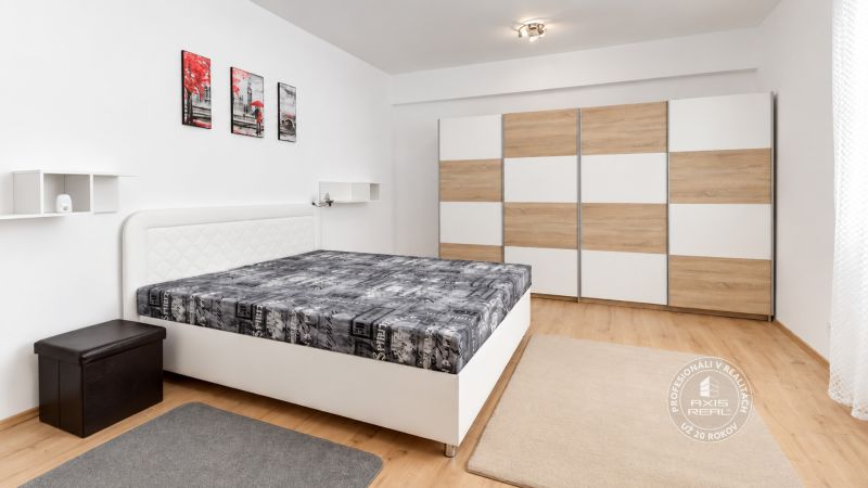 Schlafzimmer mit Bett, Kleiderschrank und Holzboden in einer 2-Zimmer-Wohnung.