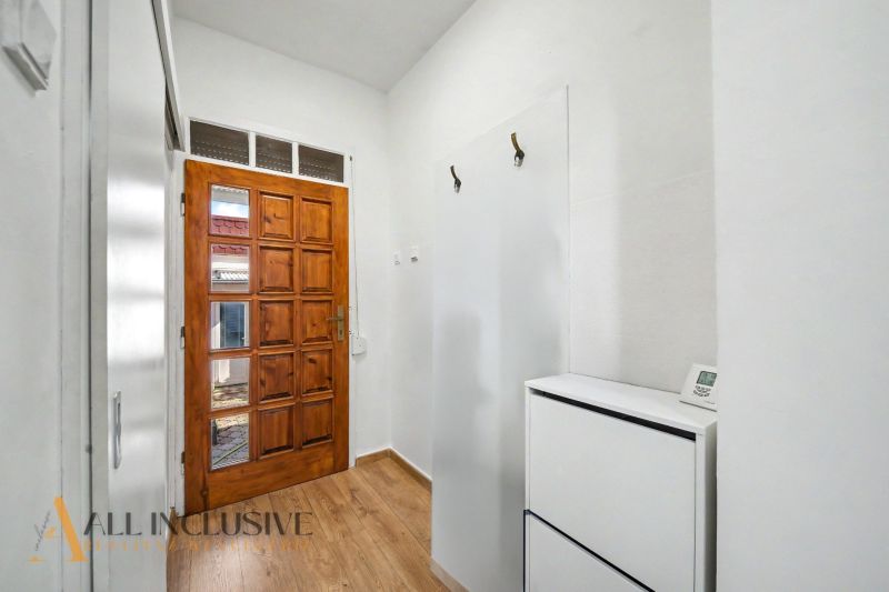 Eingangshalle in einem Einfamilienhaus mit Holztüren und einem Boden in Holzoptik.