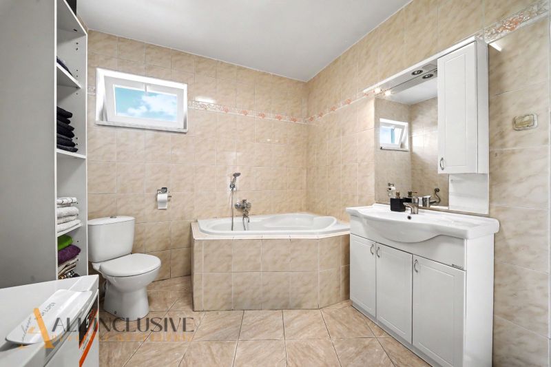 Badezimmer mit Eckbadewanne, Waschbecken und WC in einem Einfamilienhaus.