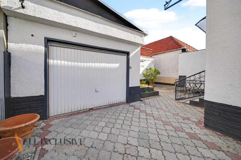 Ein Einfamilienhaus in Trstice mit Pflastersteinen und einer Garage, geeignet für sicheres Parken.