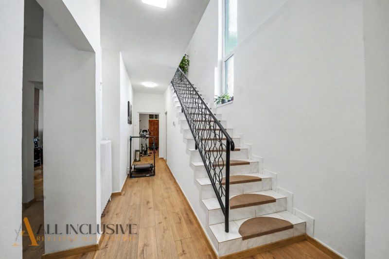 Eine Treppe mit weißen Wänden und einem Boden in Holzoptik in einem Einfamilienhaus.