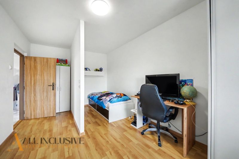 Kinderzimmer in einem Einfamilienhaus mit Schreibtisch und Boden in Holzoptik.