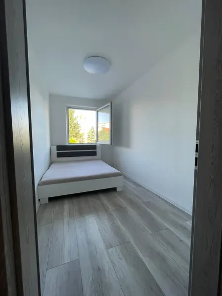 Schlafzimmer mit Bett und Holzboden in einer 2-Zimmer-Wohnung.