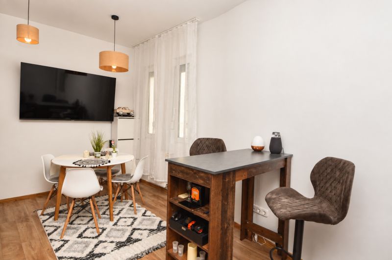 Innenraum einer Einzimmerwohnung mit Holzboden und Esstisch.