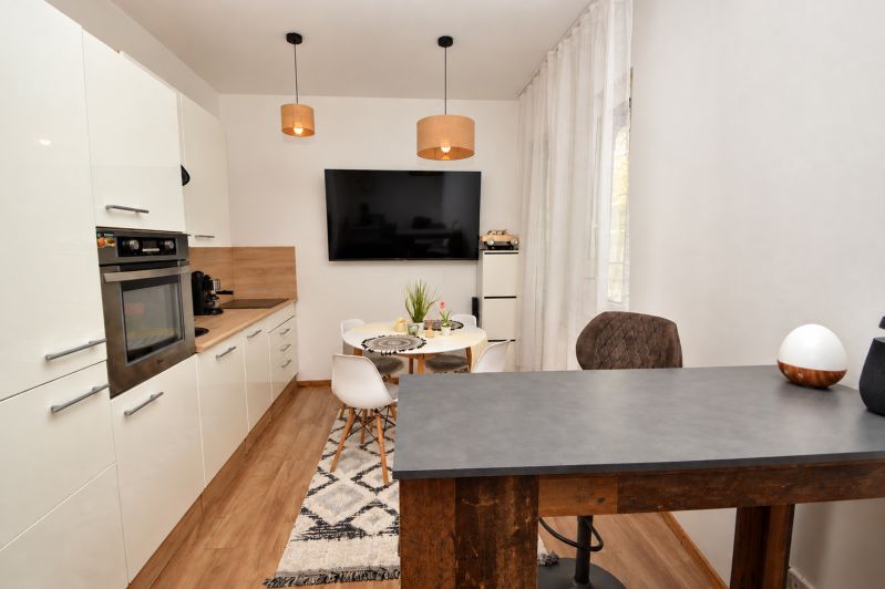 Küche in einer Einzimmerwohnung mit Holzboden und Esstisch.