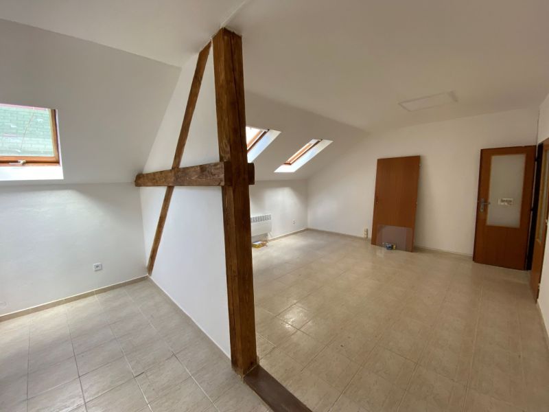 Dachbodenkantoor mit Holzbalken und schrägen Fenstern, Boden mit Holzdekor.
