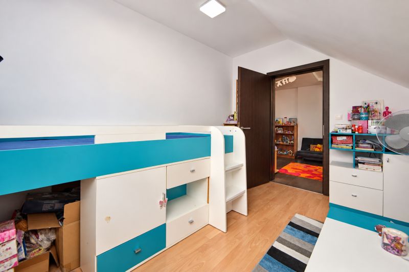 Kinderzimmer in einem Einfamilienhaus mit bunten Möbeln und einem Holzboden.