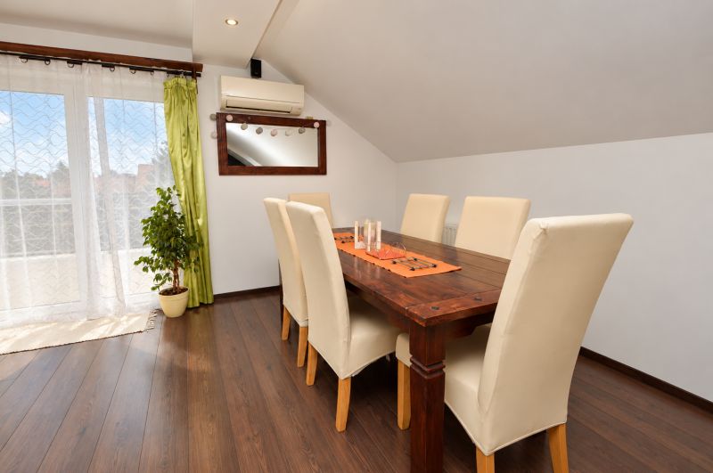 Esszimmer in einem Einfamilienhaus mit Holzboden und großen Fenstern.