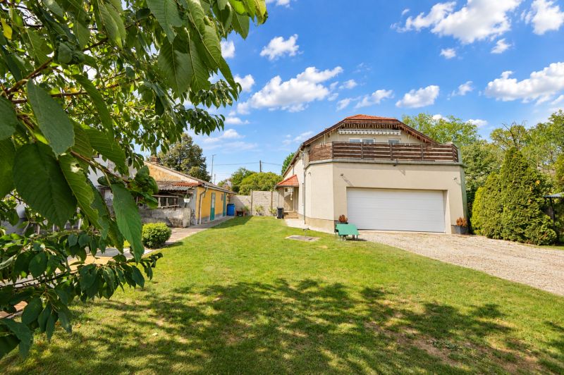 Einfamilienhaus in Mosonmagyaróvár mit großem Garten und Garage, umgeben von Grün.