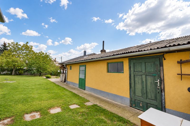 Der Garten eines Einfamilienhauses in Mosonmagyaróvár mit Rasen und Bäumen.