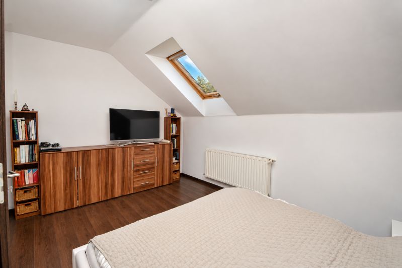 Dachbodenschlafzimmer mit Holzboden in einem Einfamilienhaus.