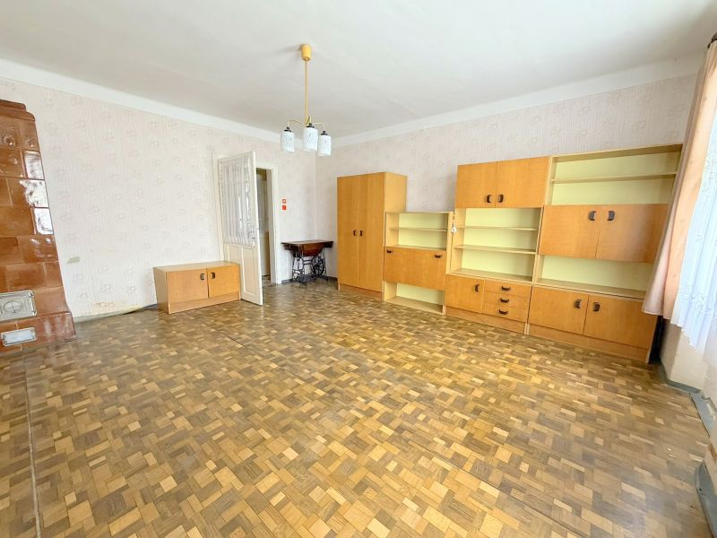 Wohnzimmer mit Holzboden, hellen Möbeln und einem Kaminofen in einem Einfamilienhaus.
