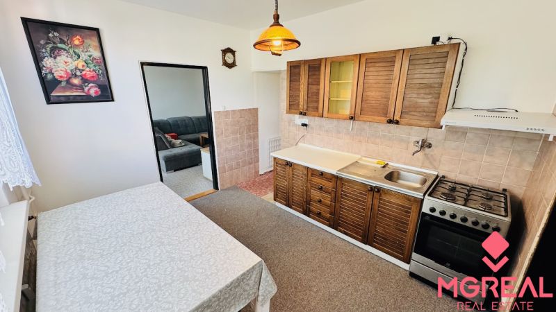 Küche in einer 3-Zimmer-Wohnung mit einem Gasherd und einer Küchenzeile mit Holzdekor.