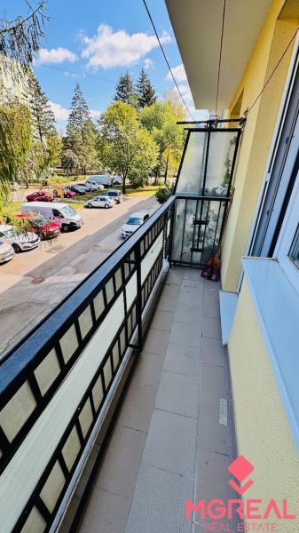 Ein Balkon mit Blick auf Bäume und Autos in der Nádražná-Straße in Partizánske, der Raum einer 3-Zimmer-Wohnung.
