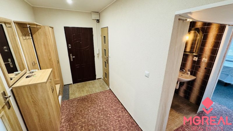 Der Flur in der 3-Zimmer-Wohnung mit Einbauschränken und einem Waschbecken mit Beleuchtung.