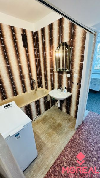 Badezimmer mit Retro-Fliesen und Badewanne, Waschmaschine in einer 3-Zimmer-Wohnung.