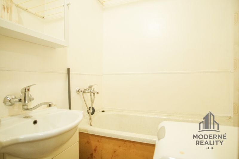 Badezimmer mit Badewanne und Waschbecken in einer 2-Zimmer-Wohnung.