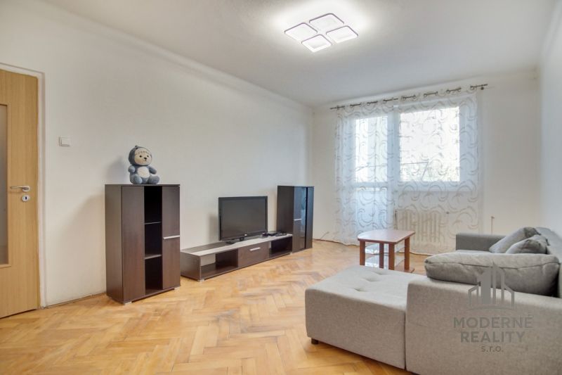Wohnzimmer in einer Zweizimmerwohnung mit Holzboden und hellem Interieur.