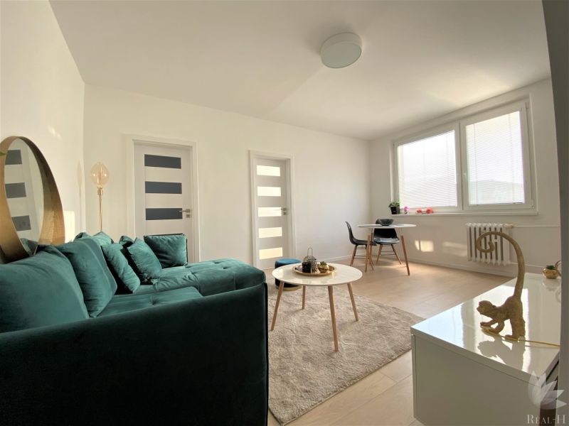 Helles Wohnzimmer in einer 3-Zimmer-Wohnung mit Sofa, Tisch und Essecke.