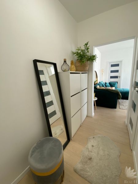 Flur mit weißen Möbeln, Spiegel und Dekorationsgegenständen in einer 3-Zimmer-Wohnung.