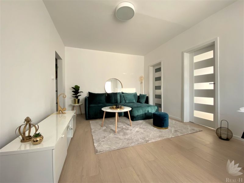 Wohnzimmer mit Sofa und Dekorationen in einer 3-Zimmer-Wohnung, helles Interieur.