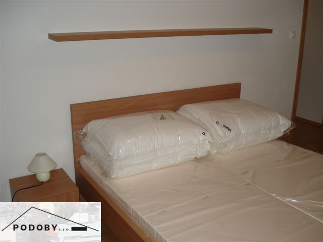 Schlafzimmer in einer 3-Zimmer-Wohnung mit Bett und Nachttischlampe.
