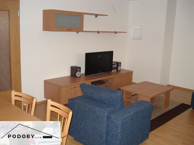 Wohnzimmer mit Holzboden, blauem Sofa und Fernseher in einer 3-Zimmer-Wohnung.