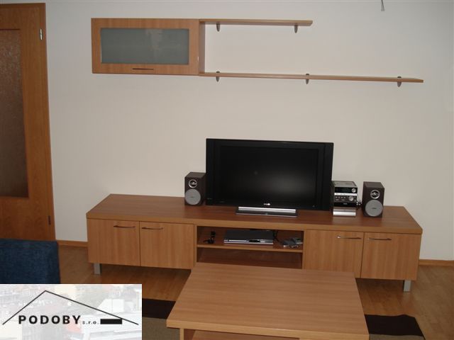 Wohnzimmer in einer 3-Zimmer-Wohnung mit Holzboden, Fernseher und Möbeln.