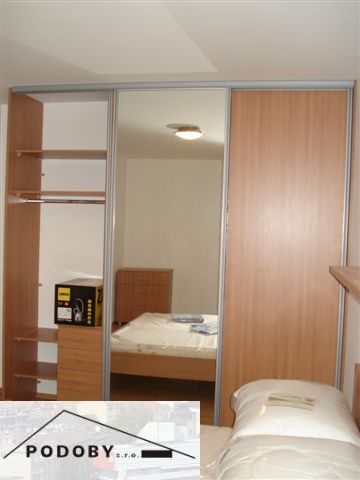 Schlafzimmer mit Holzboden und Einbauschrank in einer 3-Zimmer-Wohnung.