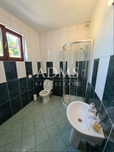 Badezimmer mit Toilette, Duschkabine und Waschbecken in Büroräumen.