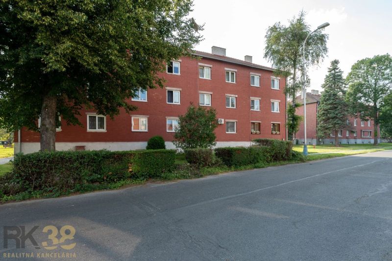 Das rote Ziegelgebäude, umgeben von Grün, in der Straße 9. mája in der Stadt Svit.
