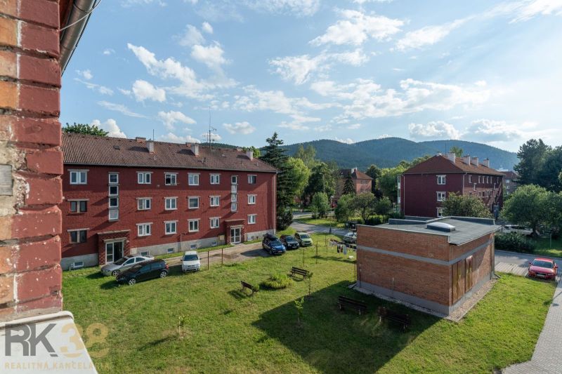 Backsteingebäude mit Parkplatz und Grünflächen in Svit in der Straße 9. mája, ideal für eine 1-Zimmer-Wohnung.