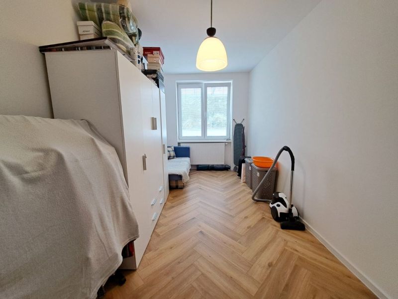 Ein helles Zimmer in einer 3-Zimmer-Wohnung mit Holzboden und Stauraum.