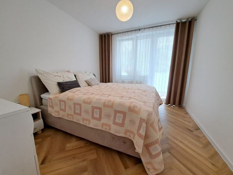 Schlafzimmer mit Doppelbett und Holzboden in einer 3-Zimmer-Wohnung.