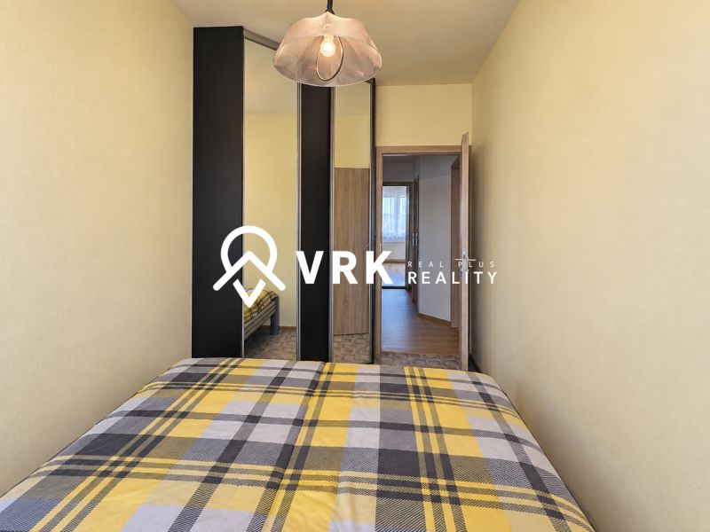 Schlafzimmer mit Einbauschrank und kariertem Überwurf in einer 3-Zimmer-Wohnung.