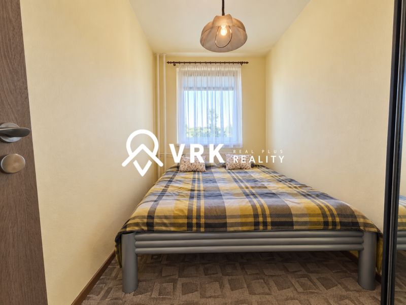 Schlafzimmer mit Bett und gemustertem Teppich in einer 3-Zimmer-Wohnung.