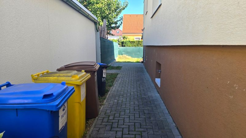 Einfamilienhaus in der Kupeckého-Straße in Piešťany, Abfallkörbe, schmaler Gehweg.