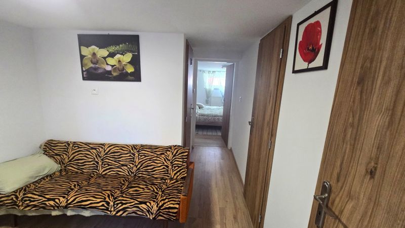 Der Flur in einem Einfamilienhaus mit einem Sofa im Zebramuster und Bildern an den Wänden.