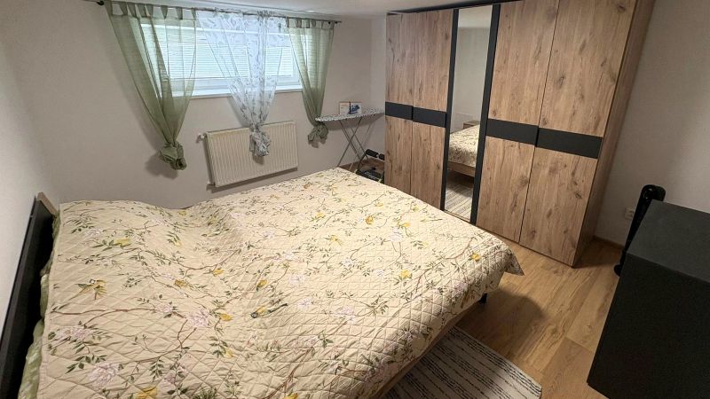 Schlafzimmer in einem Einfamilienhaus mit Holzboden, Einbauschrank und Bett.
