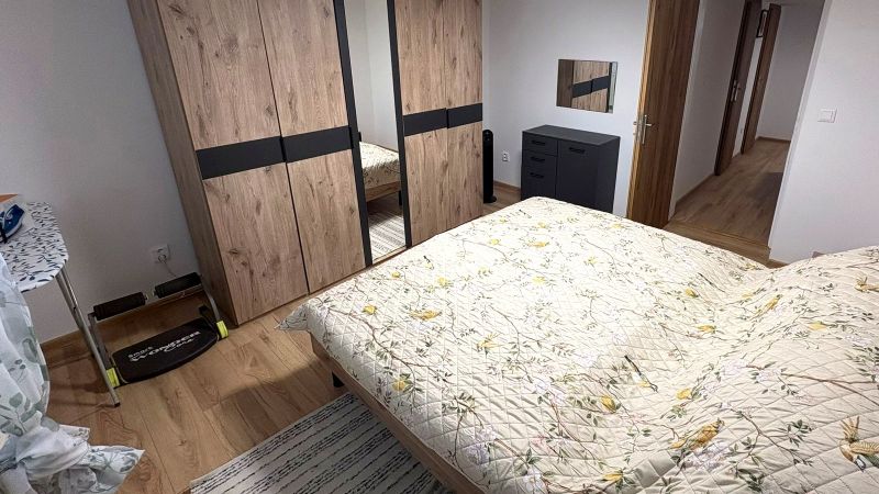 Ein Schlafzimmer mit Bett, Schrank und Holzboden in einem Einfamilienhaus.