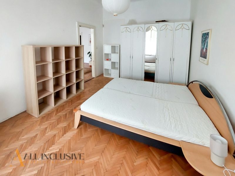 Schlafzimmer in einer 2-Zimmer-Wohnung mit Holzboden, Bett, Schrank und Regalen.