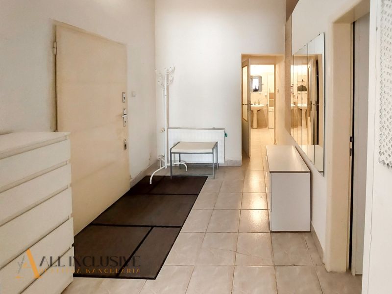 Eingangsflur in einer 2-Zimmer-Wohnung mit Fliesenboden und Spiegelwand.