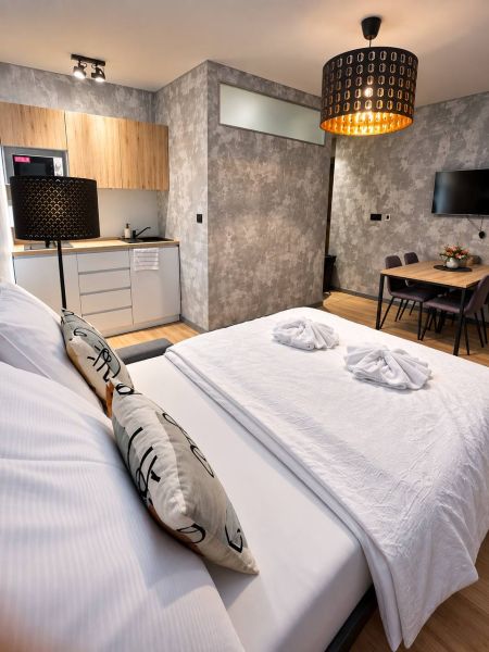 Schlafzimmer und Küchenzeile in einer 2-Zimmer-Wohnung mit Holzboden.
