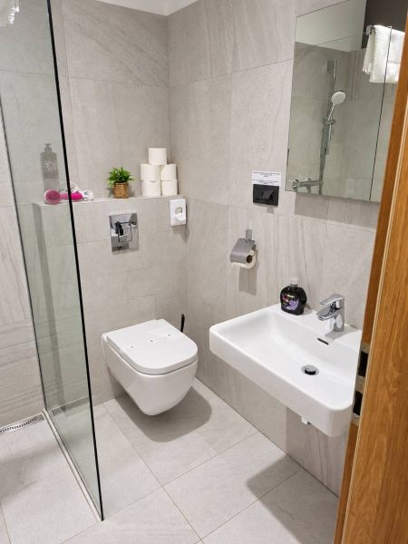 Badezimmer mit Toilette und Dusche in einer 2-Zimmer-Wohnung.