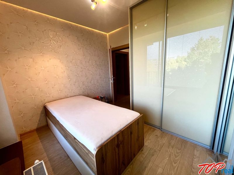 Schlafzimmer in einer 3-Zimmer-Wohnung mit Bett, Einbauschrank und dekorativer Wand.